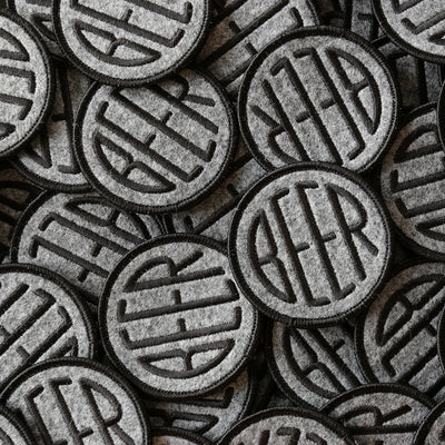 Embroidered BEER patch with black embroidery thread on heather grey felt