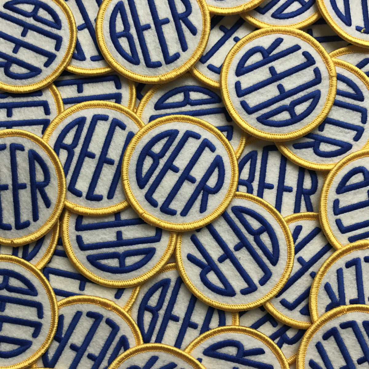 Embroidered BEER patch with blue &amp; yellow embroidery thread on off-white felt